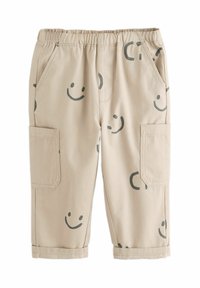 Beige cargo šortky s elastickým pasem, zdobené zelenými usměvavými obličeji a kruhovými vzory, bočními kapsami a ohrnutými lemy.