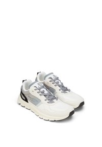 Bílé sportovní tenisky s šedými akcenty, s síťovinovým svrškem, texturovaným materiálem a černým detailem na patě. Kroužky na šněrování jsou šedé.