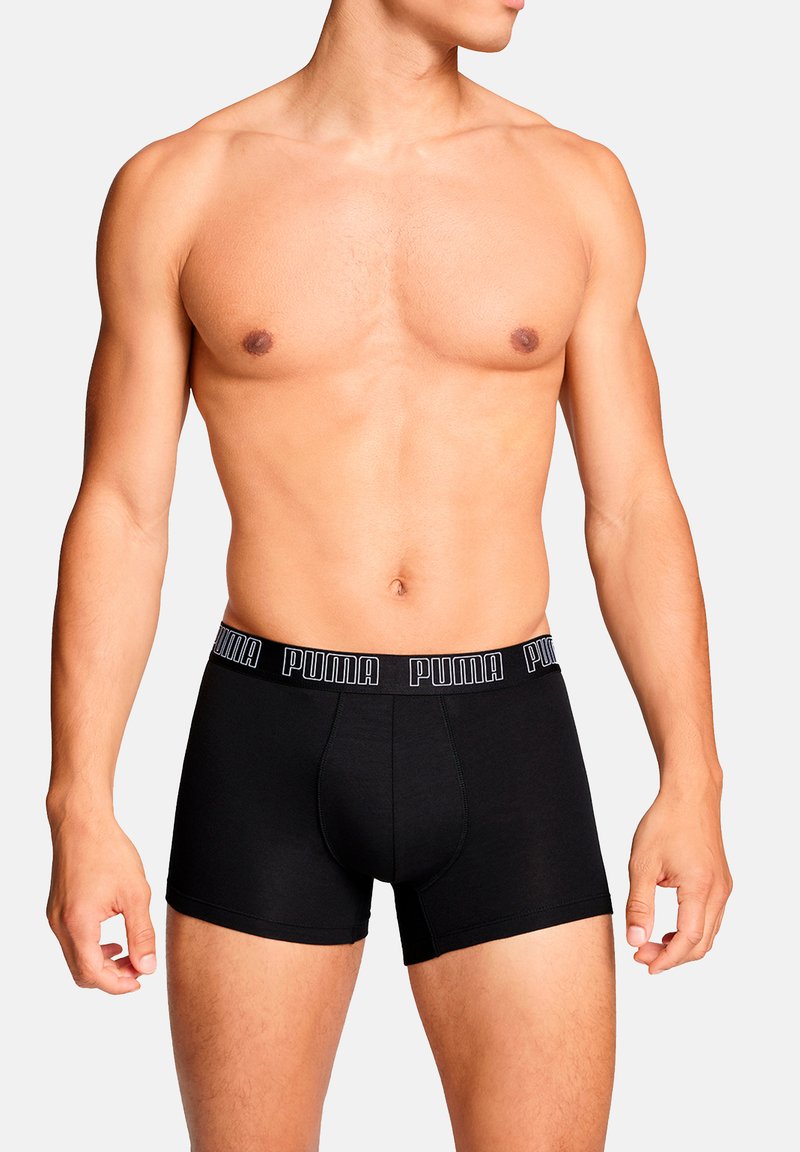 Schwarze Boxer-Shorts mit eng anliegendem Schnitt, aus weichem Stoff gefertigt. Mit einem elastischen Bund mit Markenlogo "PUMA" in kontrastierenden Farben.