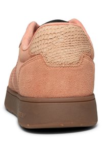 Rosa mockasin med en texturerad beige panel vid hälpartiet, brun gummisula och subtila sömnadsdetaljer.