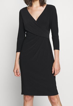 Robe noire portefeuille avec un décolleté en V, des manches trois-quarts et un détail de taille froncée. Fabriquée en tissu lisse et extensible pour le confort.