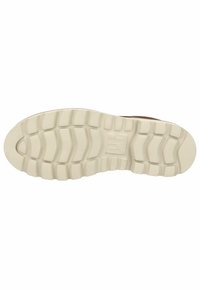 Suela de zapato con una goma beige texturizada y flexible que presenta un diseño de banda de rodadura para agarre y tracción.