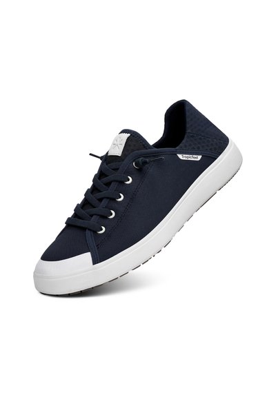 Navy modré plátěné tenisky s bílou gumovou podrážkou, kulatou špičkou, plochými tkaničkami a značkovou nášivkou na jazyku. Texturovaný akcent na patě.