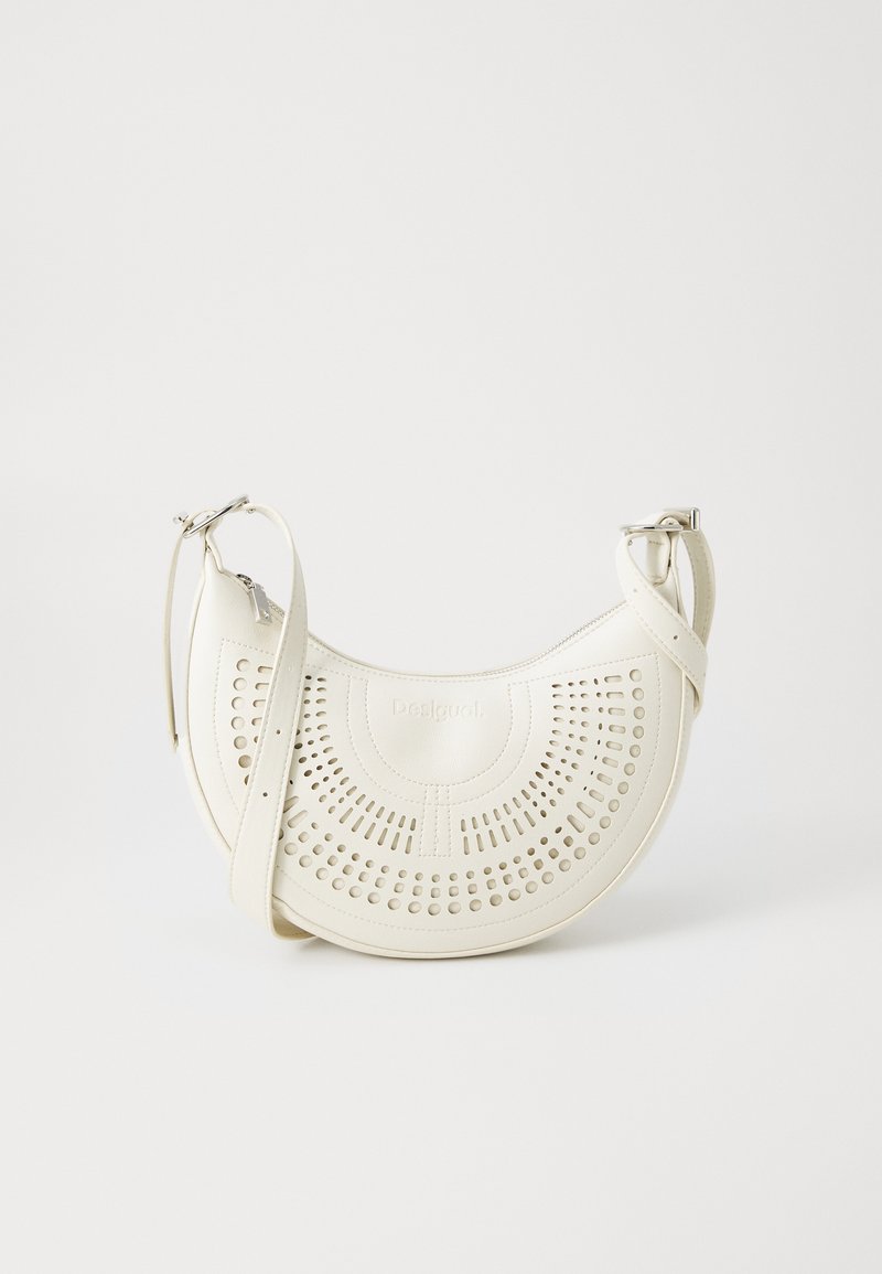 Hvid vegan læder skuldertaske med perforeret cirkulært design, justerbar strop og indgraveret logo foran. Lynlåslukning øverst.