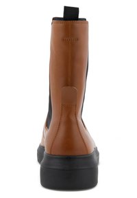 Stivale alla caviglia in pelle marrone con pannelli elastici neri, punta rotonda e suola piatta in gomma nera. Presenta una linguetta sul retro.