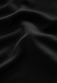 Tessuto nero texture con un delicato motivo a rete. Il materiale appare morbido e flessibile, mostrando una lieve caduta e profondità nelle pieghe.