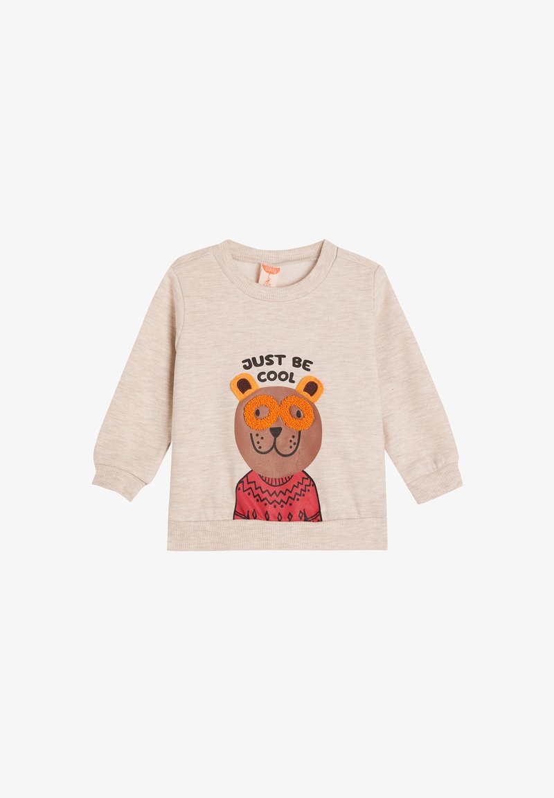 Felpa di un beige chiaro con maniche lunghe, che presenta un orso cartone con occhiali arancioni e un maglione a fantasia rossa. Il testo recita "ESSERE FRESCHI."