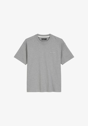 T-shirt en coton gris avec un col rond et des manches courtes. Présente un petit logo sur la poitrine gauche, un design minimaliste et une texture douce.