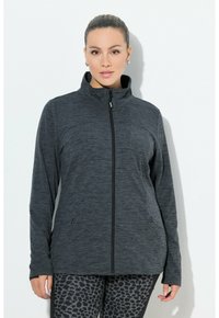 Giacca zip grigia scura con colletto alto, tessuto testurizzato, tasche laterali e design aderente, abbinata a leggings con stampa animale.