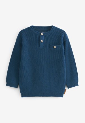 Niebieski sweter z długim rękawem, okrągłym dekoltem, dwoma drewnianymi guzikami na listwie na wysokości klatki piersiowej oraz zapinana na guzik kieszenią na piersi po lewej stronie.