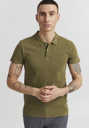 Polo majica maslinaste boje napravljena od prozračnog materijala, s klasičnom kragnom, kopčanjem na dva gumba i malim logotipom na prsima.