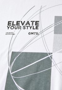 Bílá bavlněná tričko s abstraktními zelenými a šedými geometrickými vzory a černým textem. Text zní "ZVYŠTE SVŮJ STYL" a "NEOMEZENÁ DOBRODRUŽSTVÍ."