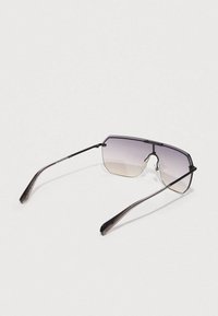 Óculos de sol com um design geométrico, lentes com degradê de cor transitando do claro para o escuro, armação fina preta e hastes pretas aerodinâmicas.
