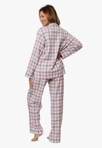 Piżama w kratę w kolorach różowym, szarym i białym. Długi rękaw z kołnierzykiem i guzikami. Spodnie mają luźny fason.