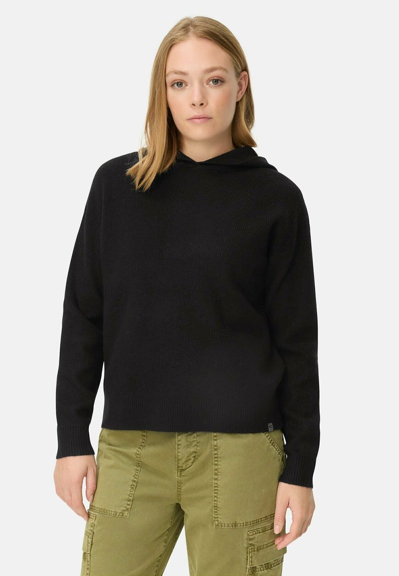 Zwarte gebreide hoodie met een losse pasvorm en ribbelstructuur, voorzien van een trekkoord capuchon en lange mouwen, gecombineerd met olijfgroene cargo pants.