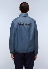 Blauwe lichtgewicht jas met een hoge kraag, elastische manchetten en tailleband. Voorzien van het prominente "NAPAPIJRI geographic" logo op de achterkant.