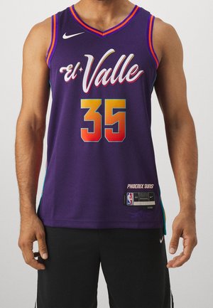 Mand iført lilla Phoenix Suns basketballtrøje med "El Valle" og nummer 35 i orange gradient foran, kombineret med sorte shorts.