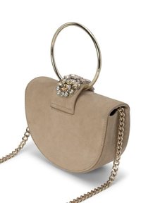 Bolso de ante beige con un asa circular de oro, cierre adornado con cristales y una correa de cadena dorada. Forma redondeada y textura suave.