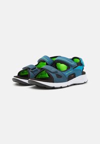Blaue und schwarze offene Sandalen mit verstellbaren Riemen, hellgrüner Innenausstattung und weißer strukturierten Sohle. Entworfen für Komfort und Stabilität.
