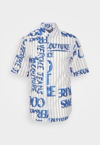 Kortärmad skjorta i lätt tyg med blå grafisk text på vit randig bakgrund; knäppning fram och klassisk krage.
