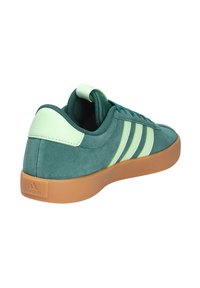 Zapatillas de ante verde con acentos en verde claro y diseño de tres rayas. Presenta una suela de goma y un collar acolchado para mayor comodidad.