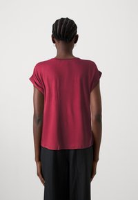 Bordový top s krátkým rukávem, volnějšího střihu a zakřiveným lemem. Měkká, hladká tkanina. Minimalistický design bez vzorů nebo akcentů.