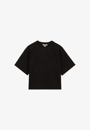 Camiseta negra oversize de manga corta con escote redondo, ajuste holgado y una pequeña etiqueta blanca visible con la talla dentro del cuello.