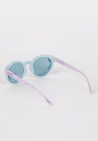 Occhiali da sole trasparenti blu con lenti rotonde, finitura glitter e bracci color viola. 'ANGEL' stampato in rosa sul braccio sinistro.