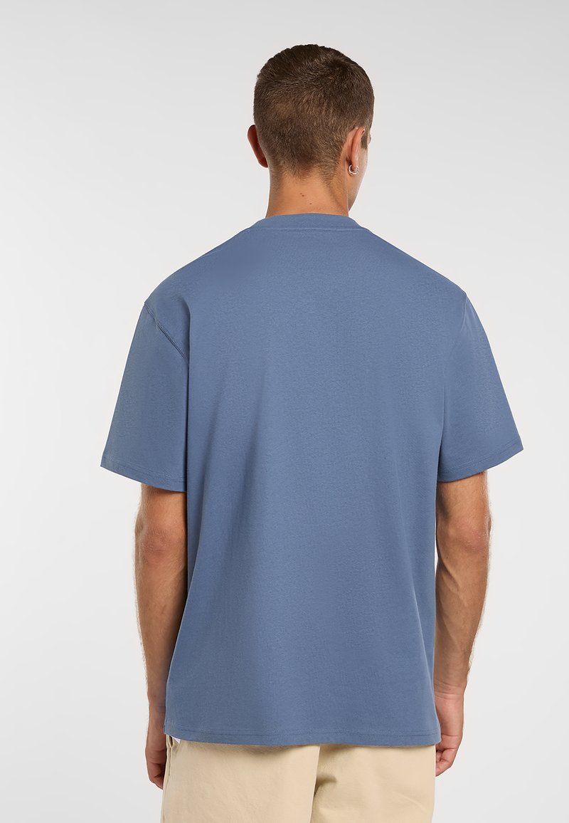 Vista posteriore di una t-shirt blu in cotone con maniche corte e collo rotondo, caratterizzata da una texture liscia e una vestibilità comoda.