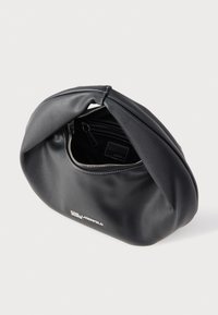 Μαύρη μαλακή δερμάτινη θήκη με ασημένιο φερμουάρ μερικώς ανοιχτό, εκτεθειμένη εσωτερική τσέπη και μικρό μεταλλικό λογότυπο μπροστά.