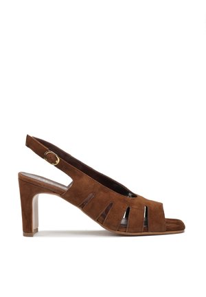 Brązowy sandał na obcasie z zamszu, z odkrytymi palcami, paskiem z tyłu i wycięciami, złotą klamrą oraz średniej wysokości słupkowym obcasem, widoczny z boku.