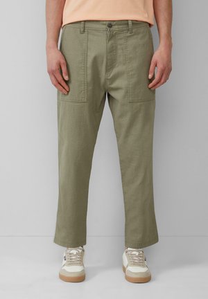Khaki cargo pants with a straight cut, featuring large side pockets and a smooth texture. Paired with white sneakers.