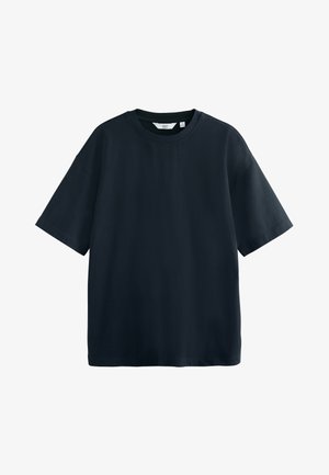 T-shirt noir à manches courtes en coton. Il présente un col rond côtelé et une coupe ample et décontractée avec un ourlet droit.