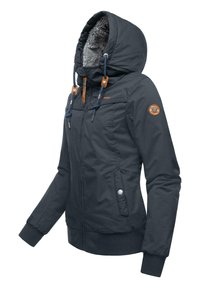 Veste isolante bleu marine avec capuche, doublure en fourrure, fermeture éclair à l'avant et accents à cordon. Elle présente des poignets côtelés et une patch sur la manche.