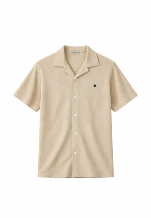 Beżowa, prążkowana koszulka z krótkim rękawem, z pięcioma białymi guzikami i małym ciemnym haftowanym logo na lewej piersi.