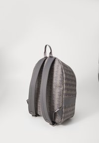 Zaino in tessuto grigio con motivo geometrico, forma curvata, spallacci imbottiti e manico superiore per il trasporto.