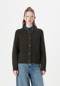Dark green knitted cardigan with a round neckline and button closure. Features a textured finish and ribbed cuffs. Worn over a blue shirt.