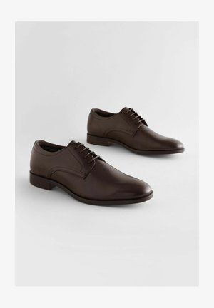 Scarpe da uomo in pelle marrone con finitura liscia, punta affusolata e allacciatura a sei fori. Design minimalista con tacco basso.