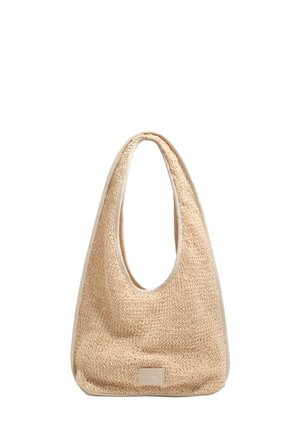Bolso tote beige tejido con asas anchas y redondeadas y una pequeña etiqueta rectangular centrada cerca de la parte inferior delantera.