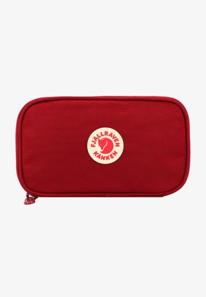 Borsa rettangolare rossa realizzata in tessuto resistente, con un logo circolare crema e rosso al centro. Chiusura con cerniera su un lato.