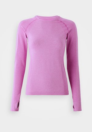 Long-sleeve athletic top in light pink with a fitted design. Features textured side panels and thumbholes at cuffs for added functionality.