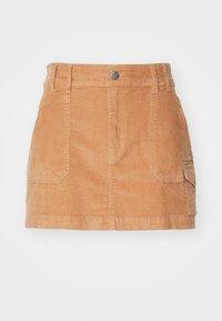 Mini-jupe en velours côtelé beige avec poches avant, passants pour ceinture, fermeture par bouton et poche latérale avec rabat sur fond blanc.