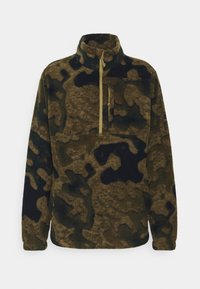 Chaqueta de forro polar en camuflaje marrón y negro con cuello alto y bolsillo con cremallera en el pecho, mangas largas y cierre con cremallera en el cuello.