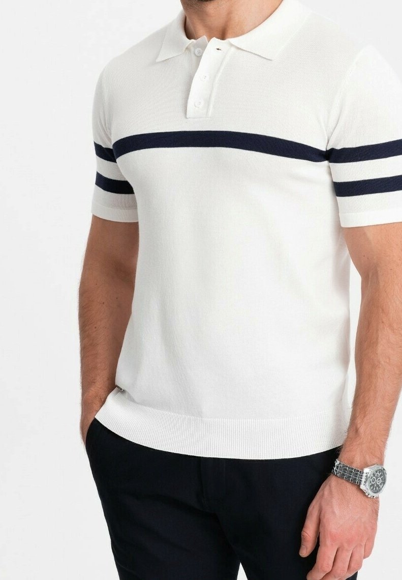 Homme portant un polo blanc à manches courtes avec des rayures horizontales bleu marine sur la poitrine et les manches, pantalon noir et montre-bracelet argentée.