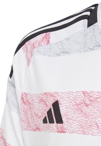 Maglietta sportiva bianca con un motivo diagonale in rosa e azzurro chiaro. Accenti neri comprendono tre strisce e un logo Adidas sul davanti.