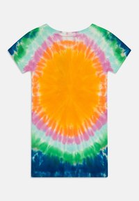 Puuvillateesärk on sidumisega muster, mille keskosaks on oranž ring, mida ümbritsevad roosa, roheline ja sinine spiraalid. Lühikesed varrukad, ümmargune kaelus.