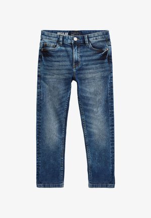 Siniset tavanomaisen malliset farkut, joissa on etutaskut ja pieni tasku, vyölenkit ja napillinen kiinnitys, ja haalistuneet yksityiskohdat reisissä ja polvissa.