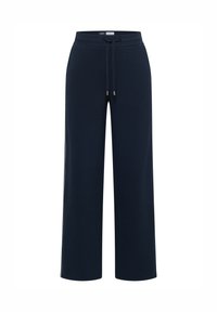 Granatowe, szerokie spodnie dresowe z miękkiego materiału, z elastycznym pasem i sznurkiem zakończonym metalowymi końcówkami. Brak widocznych kieszeni.
