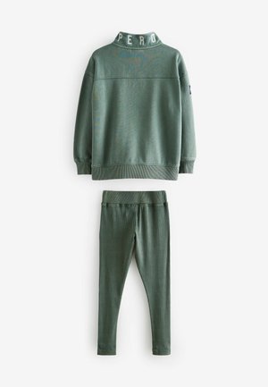 Zelený dvojdielny outfit obsahujúci polokošeľu s detailom "PER" a rebrované legíny. Mäkko tkanina s hladkým povrchom.