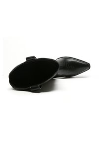 Botín de cuero negro hasta el tobillo con puntera afilada y detalles de costura lateral, que presenta una textura suave y un diseño elegante y minimalista.